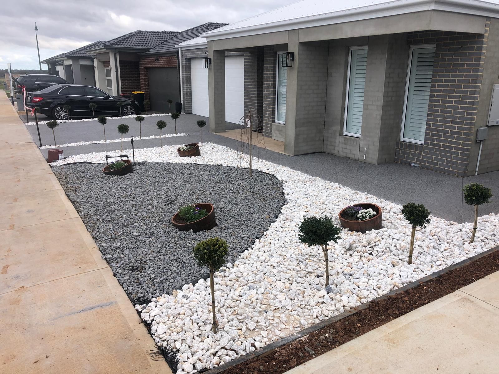 Finished front yard with stone landscaping and new plantings